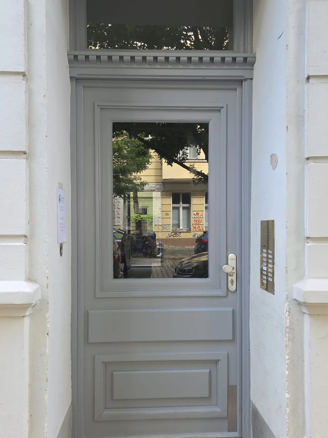 Dieselbe Altbau-Haustür in Berlin nach dem Aufarbeiten, neu lackiert