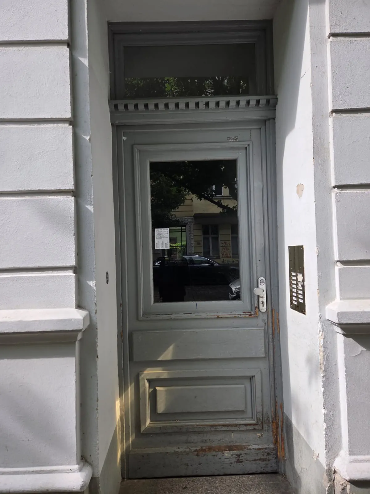 Altbau-Haustür in Berlin vor dem Aufarbeiten, Lack abgeplatzt und Holz unten morsch