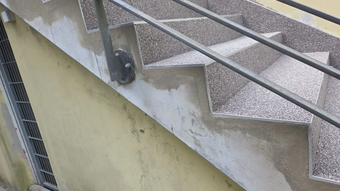 Steinteppich-Treppe mit Geländer an einem Berliner Hofzugang