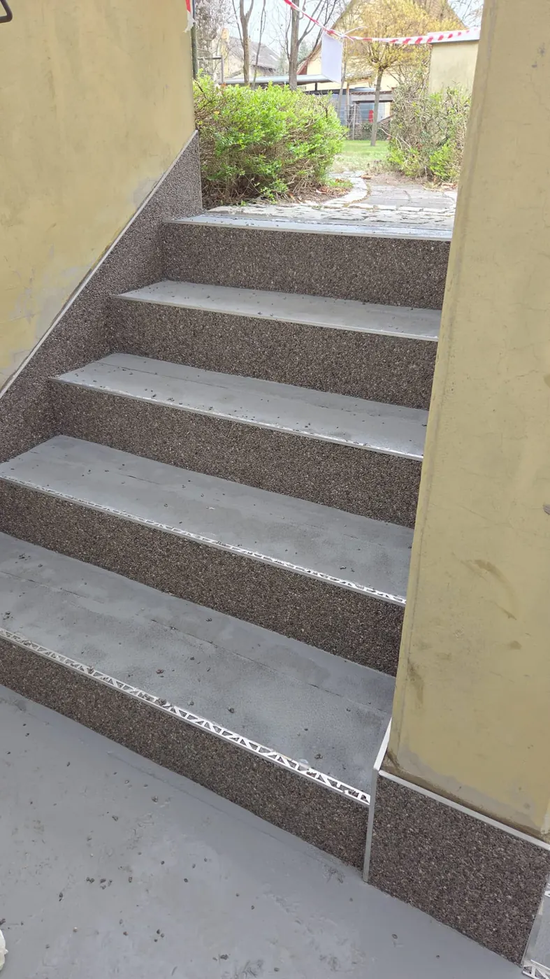 Außentreppe in Berlin halb mit Steinteppich belegt, halb grundiert