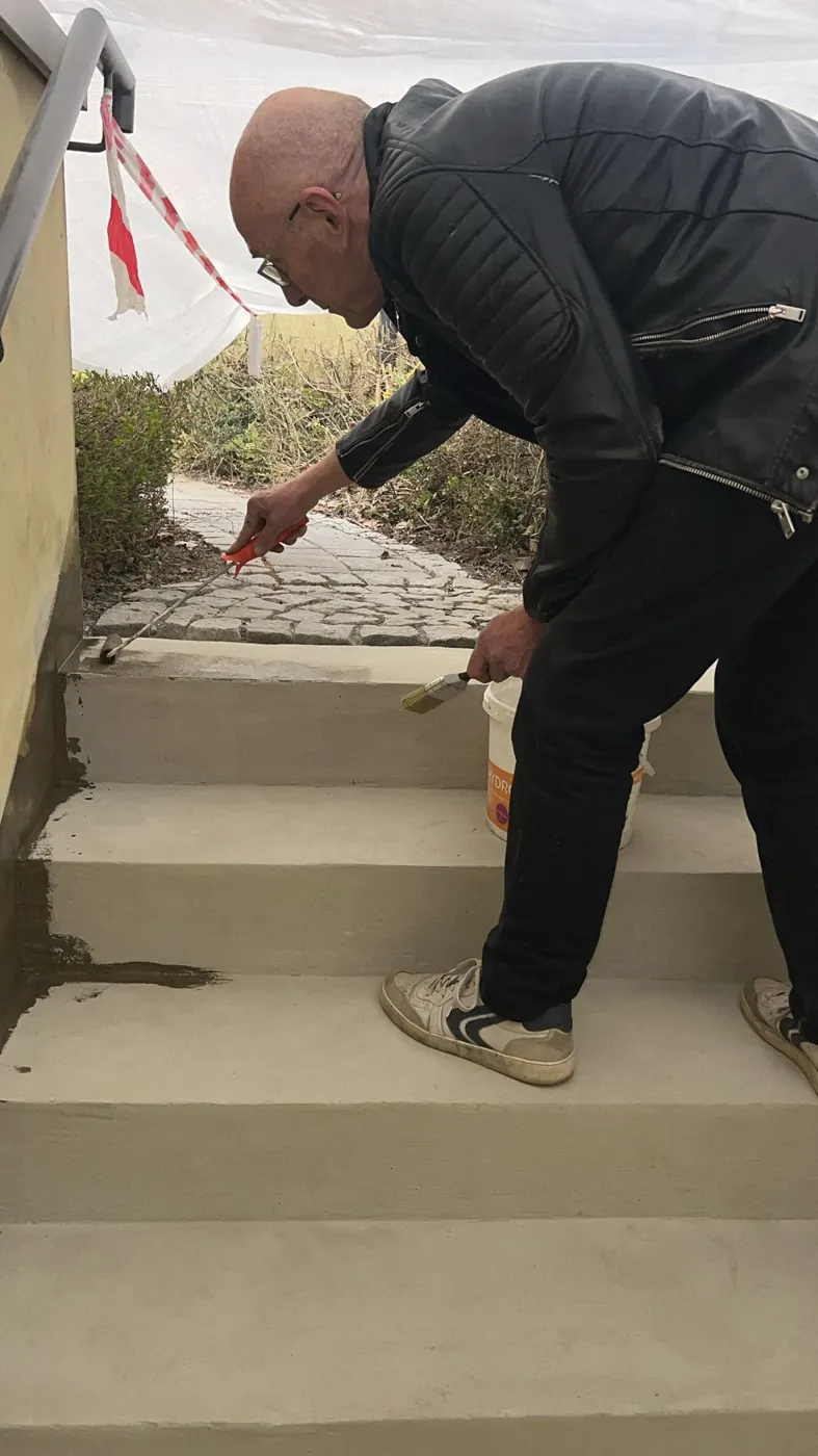 Uwe Ebert setzt Kantenprofile an einer Treppe vor dem Steinteppich