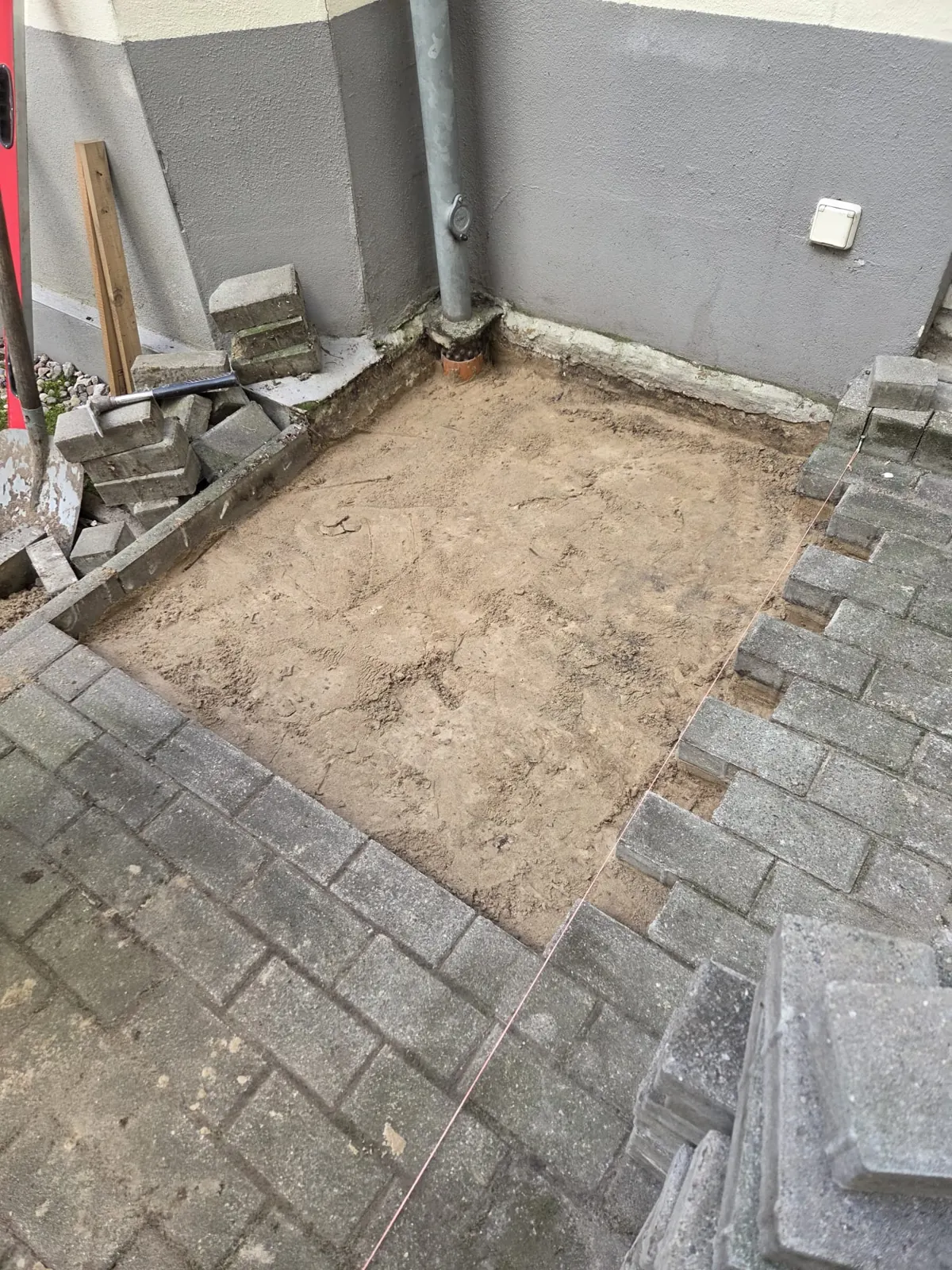 Neuer Fallrohranschluss und vorbereitetes Planum unter der Terrasse