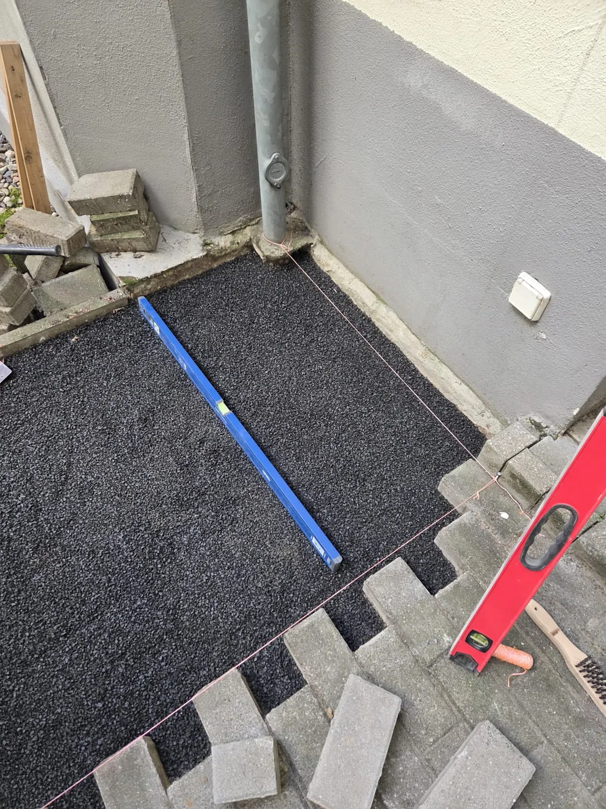 Splittbett für die Terrasse wird mit der Richtlatte abgezogen