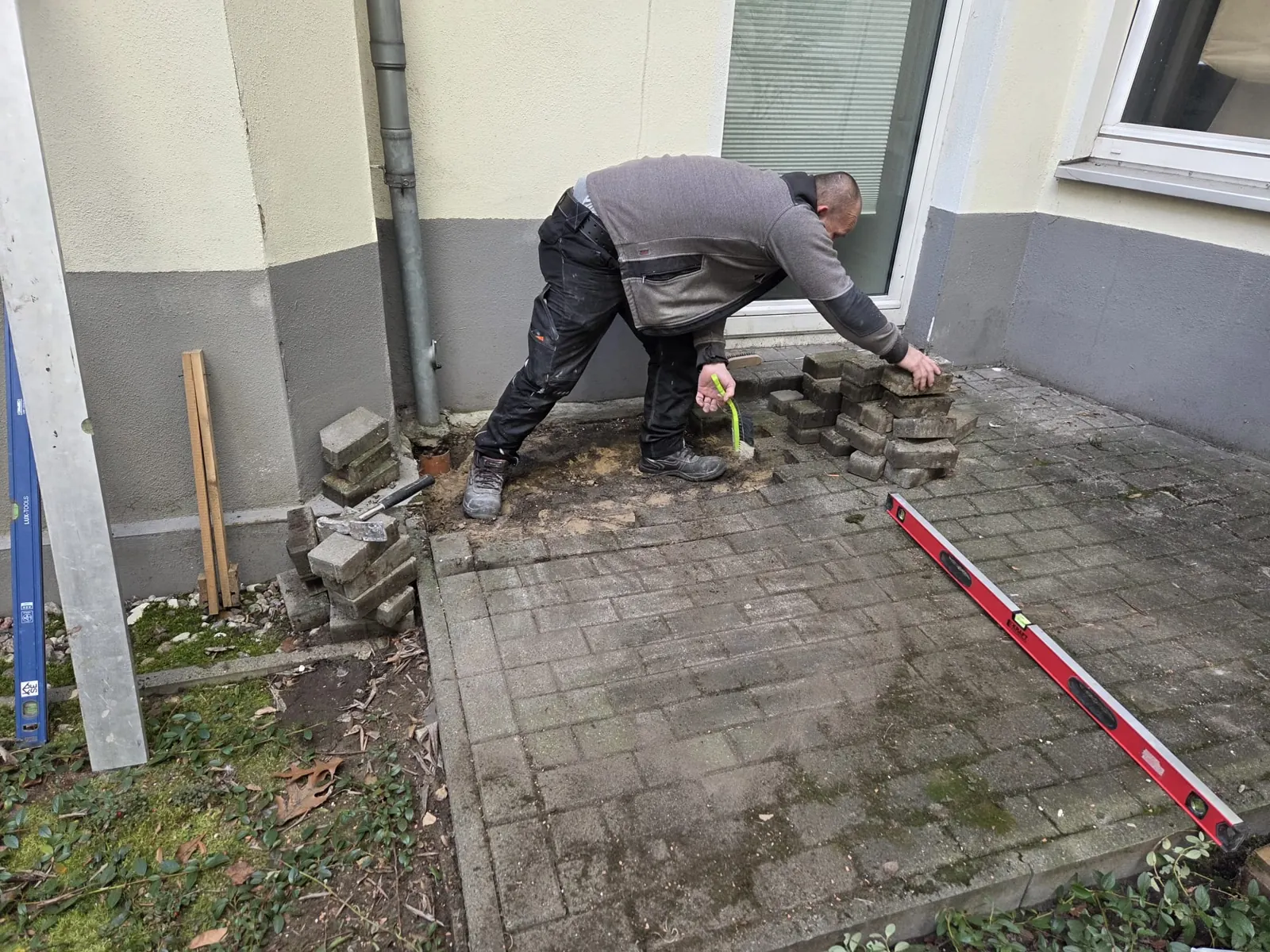 Terrasse sanieren in Berlin: Terrassenplatten werden nach der Reparatur der Dachentwässerung neu verlegt